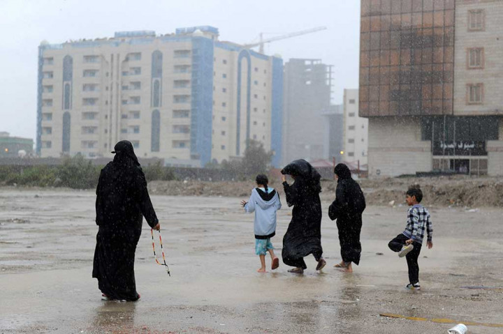 Warga nekad menerjang hujan deras di Kota Jeddah. Hujan deras diperkirakan akan berlangsung setidaknya sampai Rabu, 22 November 2017. AFP/Amer Hilabi