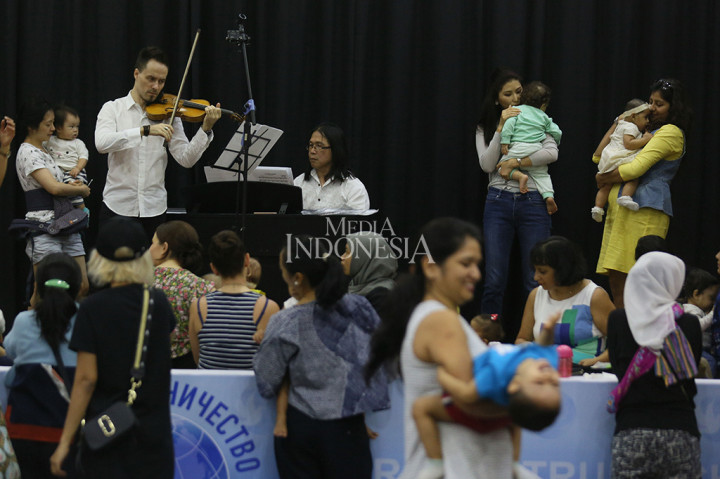 Musisi asal Rusia German Dmitriev menghibur ibu dan balita dalam penampilan musik untuk Balita di Pusat Kebudayaan Rusia.
