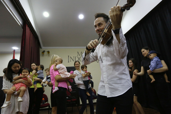 German Dmitriev bersama ibu dan balita berbaur di satu ruangan saat pertunjukan berlangsung.