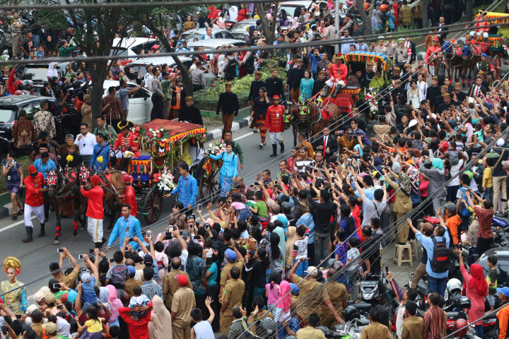 Masyarakat terlihat antusias menyaksikan prosesi kirab dalam resepsi pernikahan Kahiyang Ayu-Bobby Nasution. ANTARA/Irsan Mulyadi
