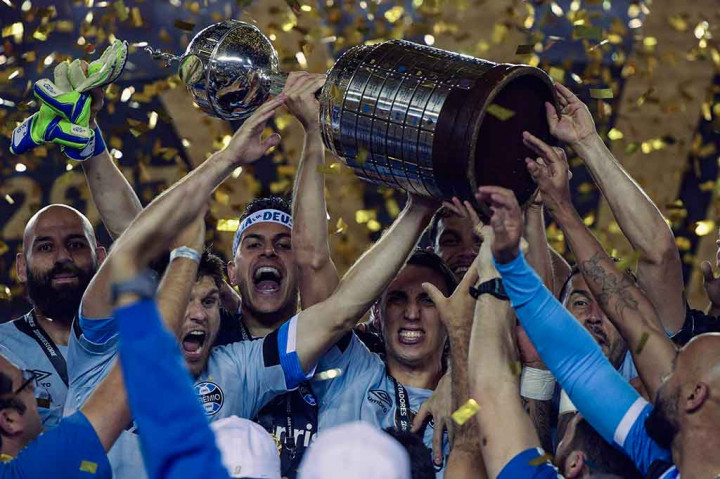 Para pemain Gremio meluapkan kegembiraan mereka sembali mengangkat trofi Copa Libertadores yang baru saja mereka raih.