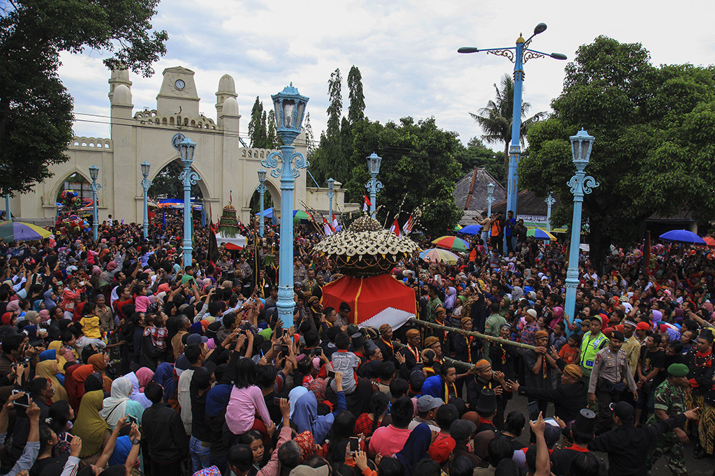 Abdi dalem Keraton Kasunanan Surakarta Hadiningrat mengarak gunungan sebelum diperebutkan dalam perayaan Grebeg Maulud di Masjid Agung Solo, Jawa Tengah. Dalam puncak perayaan untuk memperingati hari kelahiran Nabi Muhammad SAW tersebut pihak keraton setempat menghadirkan sebanyak dua pasang Gunungan laki-laki dan perempuan untuk diperebutkan warga dan abdi dalem. ANTARA/Maulana Surya