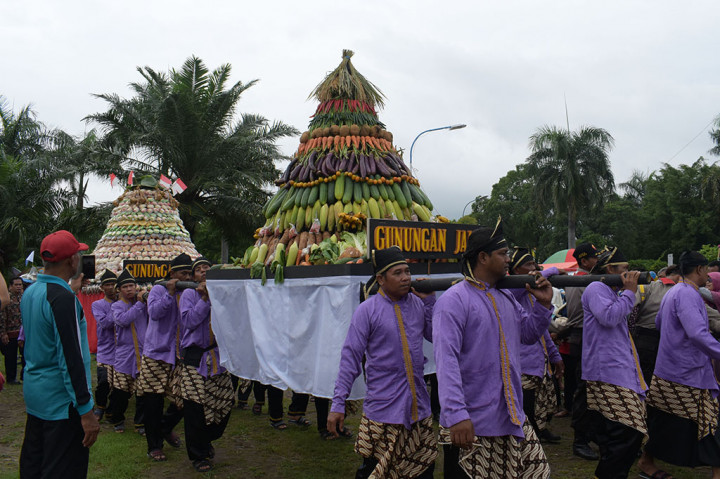 Sejumlah orang mengusung gunungan terbuat dari rangkaian hasil bumi saat digelar Grebeg Maulid Nabi Muhammad SAW di Alun-alun Kota Madiun, Jawa Timur. Kegiatan kirab Gunungan Jaler dan Gunungan Estri yang terbuat dari rangkaian hasil bumi dan jajanan pasar tersebut merupakan rangkaian kegiatan Grebeg Maulid yang digelar Pemkot Madiun untuk memperingati Maulid Nabi Muhammad SAW. ANTARA/Siswowidodo