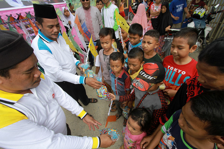 Sejumlah panitia membagikan bingkisan Walima Goroba (Waligo) pada peringatan Maulid Nabi Muhammad SAW Kabila, Kabupaten Bone Bolango, Gorontalo. Tradisi Waligo yang telah ada sejak puluhan tahun lalu tersebut dikhususkan untuk membagikan 1.000 bingkisan dan bendera warna-warni untuk anak-anak dengan menggunakan gerobak (goroba). ANTARA/Adiwinata Solihin