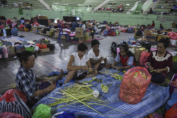 Sejumlah pengungsi membuat canang sarai di lokasi pengungsian GOR Swecapura, Klungkung, Bali.
