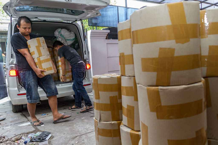 Karyawan yang bekerja di rumah yang diduga menjadi pabrik pembuataan pil PCC memindahkan barang bukti di bawah pengawasan petugas saat penggerebekan oleh BNN, di Jalan Raya Halmahera, Semarang, Jawa Tengah, Minggu. ANTARA/Aji Styawan