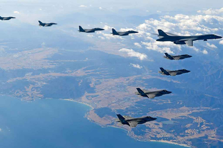 Foto yang dikeluarkan oleh Kementerian Pertahanan Korea Selatan pada 6 Desember 2017 menunjukkan pesawat pembom AU AS, Lancer B-1B (kanan atas), melakukan terbang formasi bersama dua pesawat tempur AS F-35A (tengah) dan dua pesawat tempur AS F-35B (bawah), serta dua pesawat tempur Korsel F-16 (kiri) dan dua jet tempur F-15K (tengah atas), selama latihan gabungan militer di Korsel.