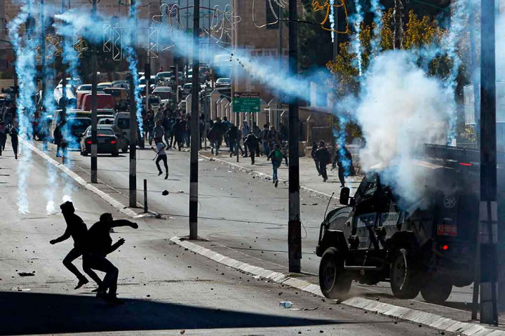 Tembakan gas air mata tentara Israel dibalas dengan lemparan batu oleh warga palestina di Bethlehem, Tepi Barat, Sabtu, 9 Desember 2017 waktu setempat. AFP/Musa Al Shaer