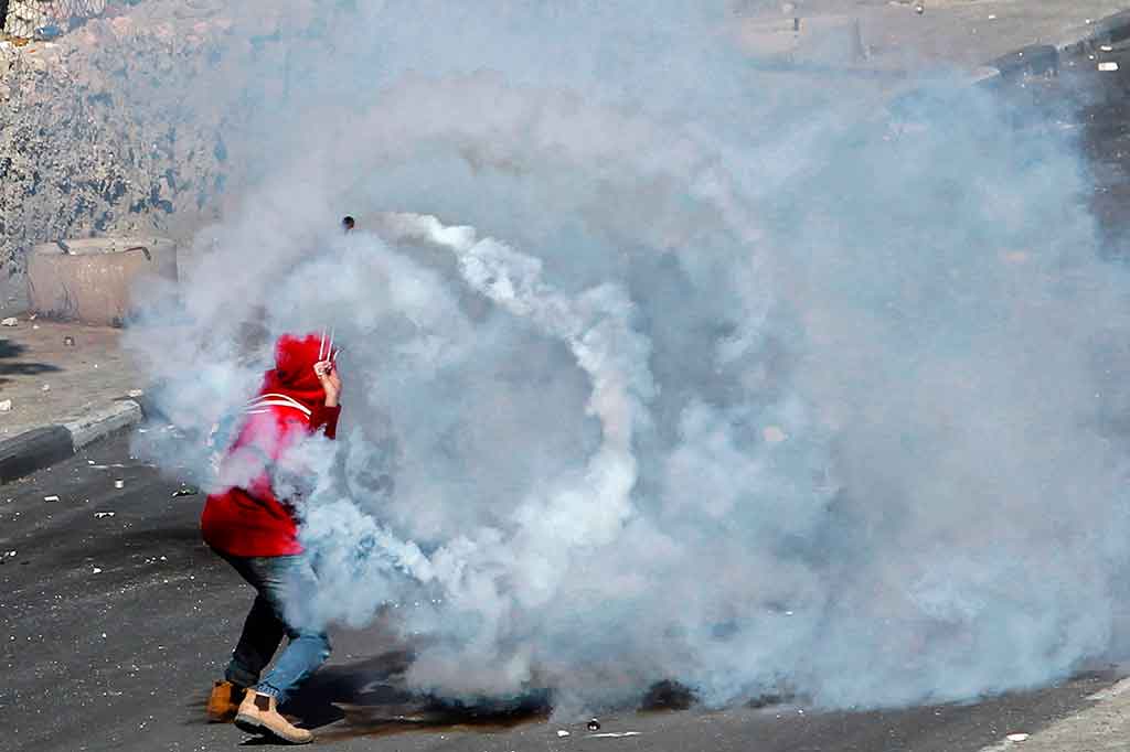 Warga Palestina kembali melemparkan gas airmata yang ditembakkan tentara Israel. AFP/Musa Al Shaer