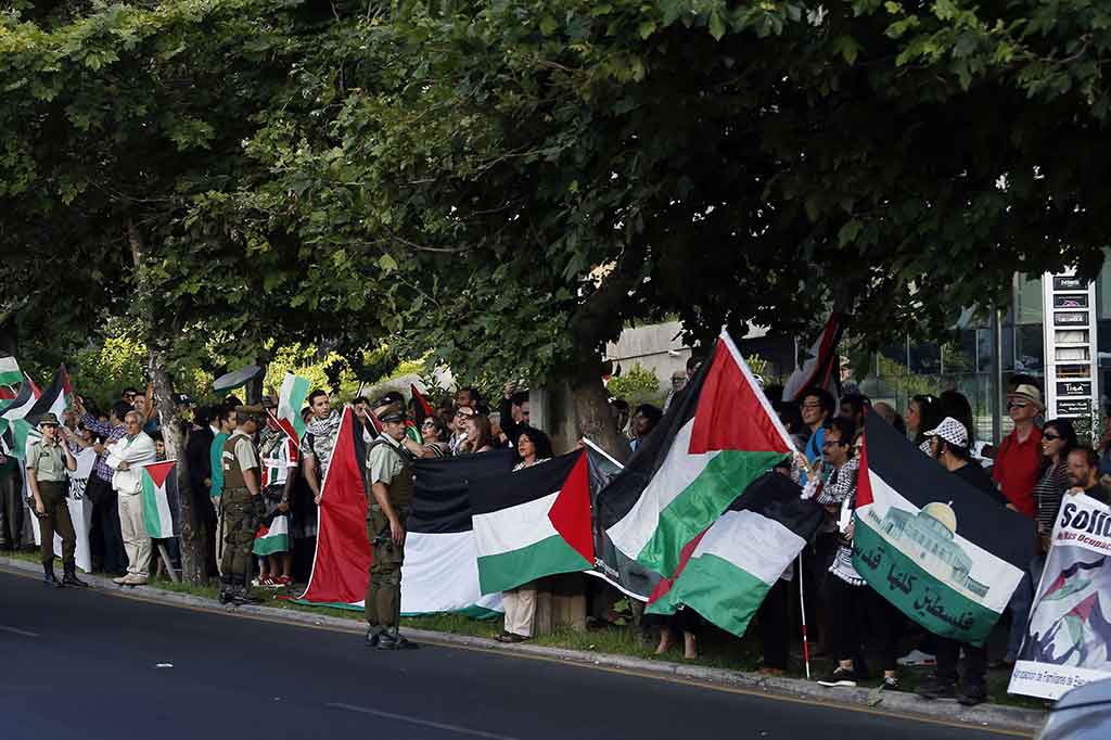 Dengan membawa bendera Palestina dan sejumlah poster, warga berunjuk rasa di depan Kedubes AS untuk Cile di Santiago, Senin, 11 Desember 2017 waktu setempat.
