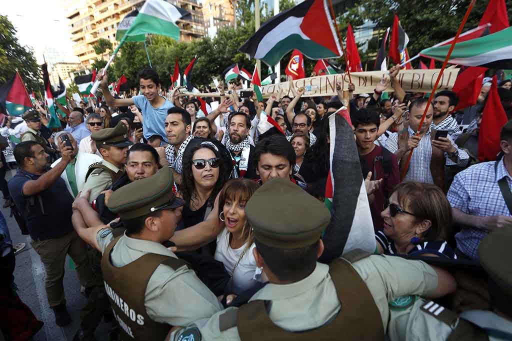 Terjadi aksi saling dorong antara pengunjuk rasa dengan polisi yang berjaga-jaga di depan Kedubes AS di Santiago.
