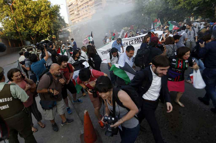 Polisi menyemprotkan air dari mobil water canon untuk membubarkan para pengunjuk rasa.