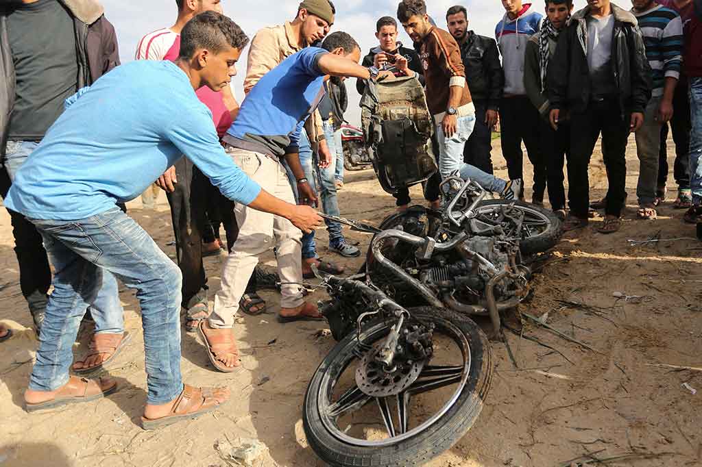 Warga memeriksa sepeda motor yang rusak berat yang dilaporkan terkena serangan udara Israel, di Beit Lahia di Jalur Gaza, Selasa, 12 Desember 2017. Beberapa saksi mata dan petugas paramedis mengatakan satu rudal Israel menghantam sepeda motor, dan menewaskan dua pengendaranya. 