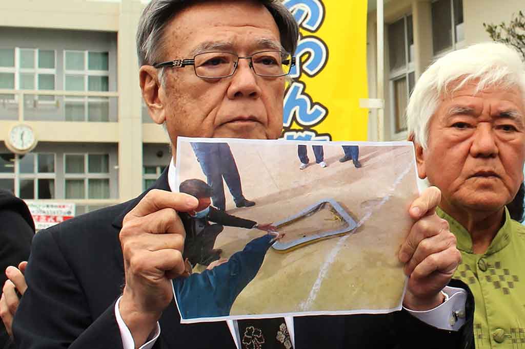 Gubernur Okinawa Takeshi Onaga menunjukkan gambar jendela helikopter militer AS yang jatuh ke sebuah lapangan sekolah di Ginowan, Okinawa, Rabu, 13 Desember 2017.