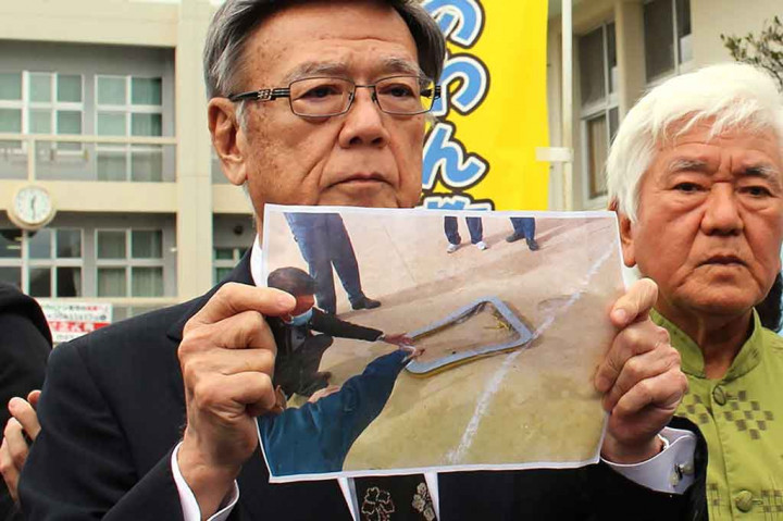 Gubernur Okinawa Takeshi Onaga menunjukkan gambar jendela helikopter militer AS yang jatuh ke sebuah lapangan sekolah di Ginowan, Okinawa, Rabu, 13 Desember 2017.