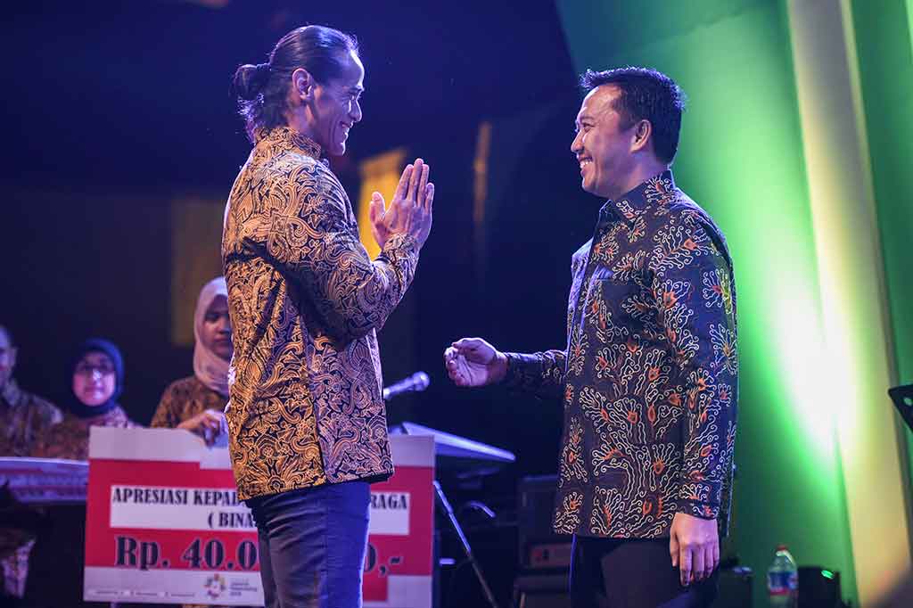 Imam Nahrawi memberikan penghargaan kepada binaragawan Ade Rai saat Malam Anugerah Legenda Olahraga Indonesia.