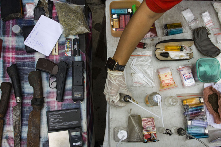Petugas kepolisian menunjukan sejumlah barang bukti hasil razia narkoba di Kampung Peninggaran, Tanah Kusir, Jakarta.