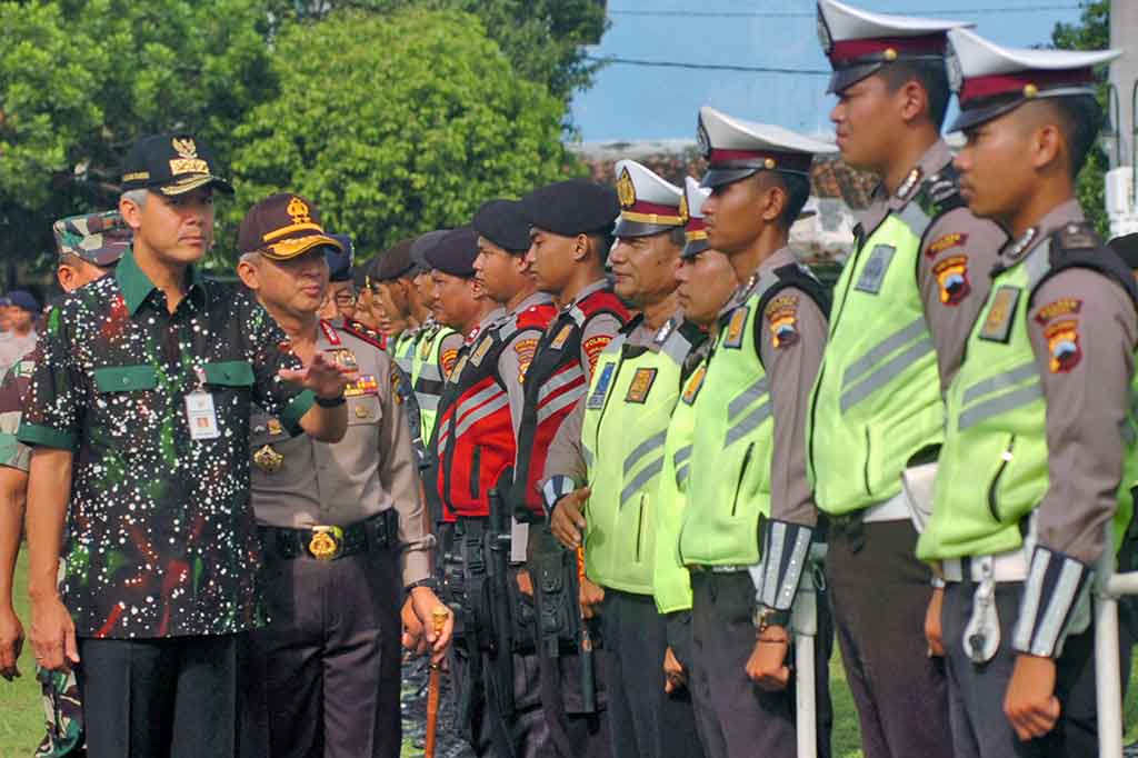 Gubernur Jateng Ganjar Pranowo didampingi Kapolda Jateng Irjen Condro Kirono (kedua kiri) memeriksa pasukan kepolisian saat apel Pasukan Operasi Lilin Candi 2017 di Alun-alun Tegal. Polda Jateng mengerahkan 11.000 personel dan TNI 12.000 personel untuk pengamanan perayaan Natal dan Tahun Baru 2018. ANTARA/Oky Lukmansyah