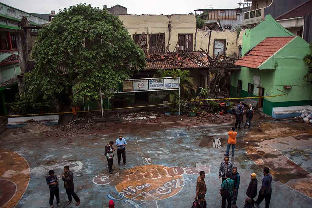Warga berada di sekitar area bangunan SMP 32 Jakarta di Pekojan, Jakarta Barat yang roboh, Kamis, 21 Desember 2017.  ANTARA/Aprillio Akbar