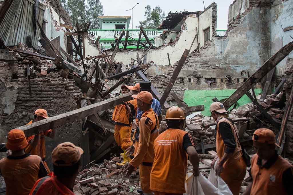 Petugas PPSU atau 'pasukan oranye' mengangkut material bangunan SMP 32 Jakarta yang roboh. ANTARA/Aprillio Akbar