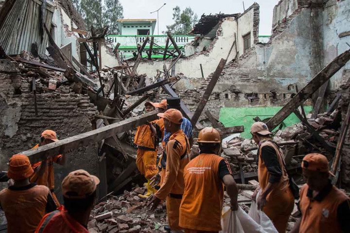Petugas PPSU atau 'pasukan oranye' mengangkut material bangunan SMP 32 Jakarta yang roboh. ANTARA/Aprillio Akbar