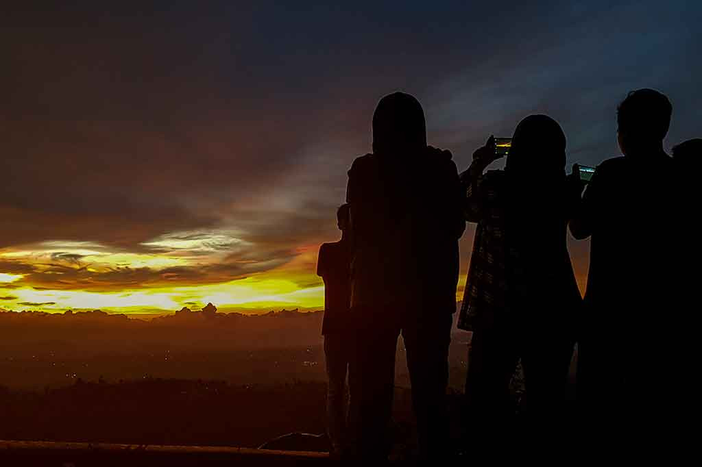 Wisatawan mengabadikan matahari terbenam di lokasi wisata Puncak Bintang, Cimenyan, Kabupaten Bandung, Jawa Barat, Jumat, 22 Desember 2017.