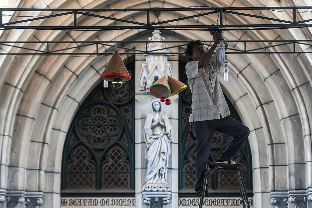Petugas memasang lampu di Gereja Katedral, Jakarta.