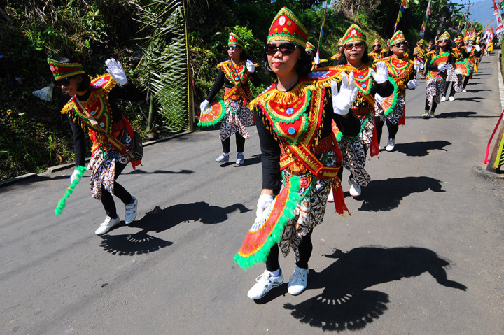 Sejumlah peserta kelompok kesenian lokal menari saat mengikuti kirab tradisi Merti Desa, di Gladaksari, Ampel, Jawa Tengah.