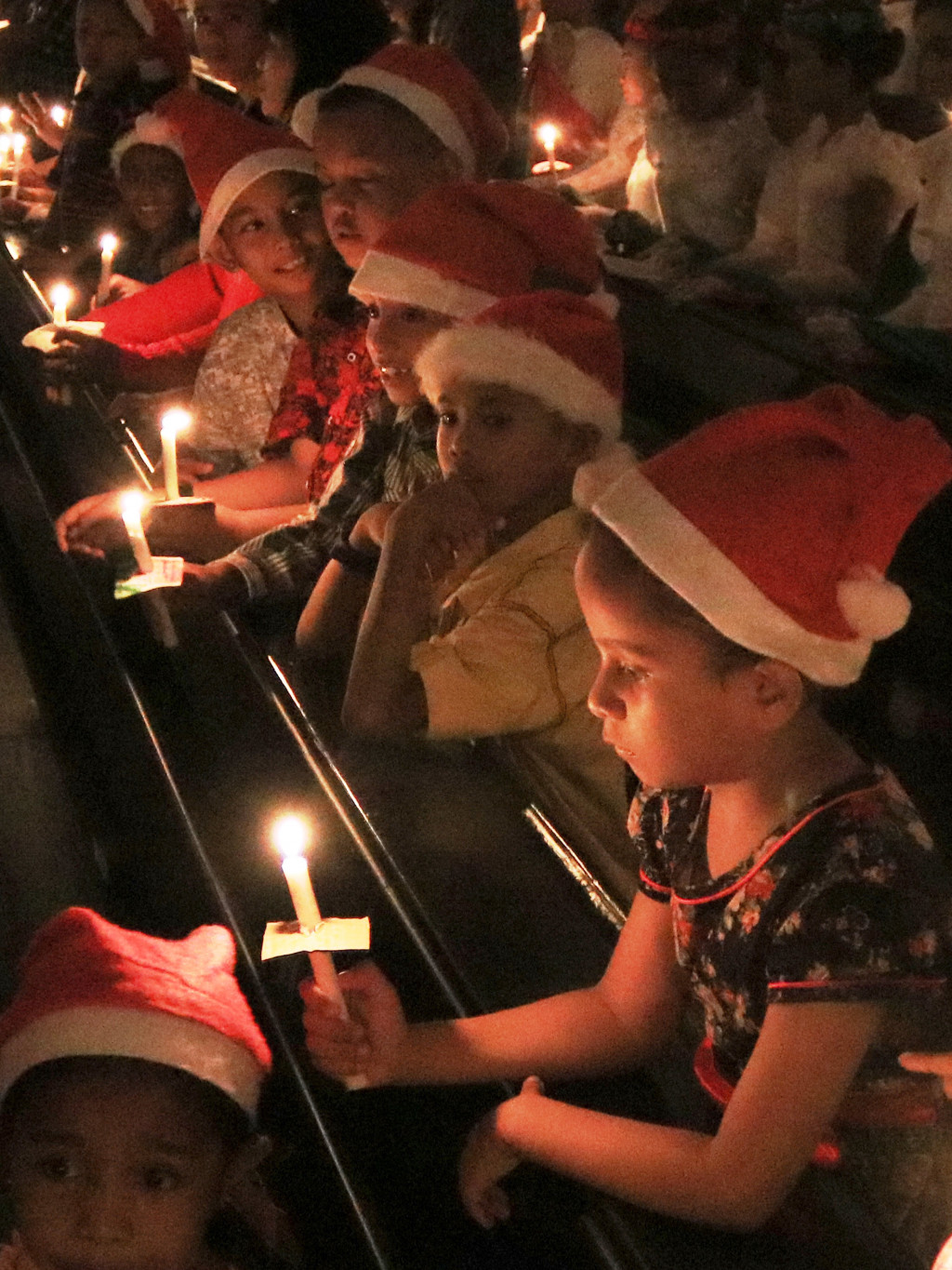 Anak-anak menyalakan lilin dalam Misa Malam Natal di Katedral Amboina, Ambon. Pengamanan perayaan malam Natal juga melibatkan swakarsa dari  organisasi pemuda Islam dan Hindu setempat. Antara Foto/Izaac Mulyawan