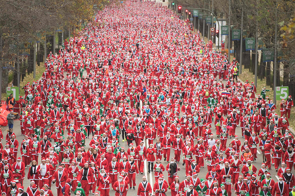 Ribuan warga Madrid, Spanyol, tampil dengan kostum Santa Claus. Mereka ikut berpartisipasi untuk laga amal. AFP PHOTO / CURTO DE LA TORRE
