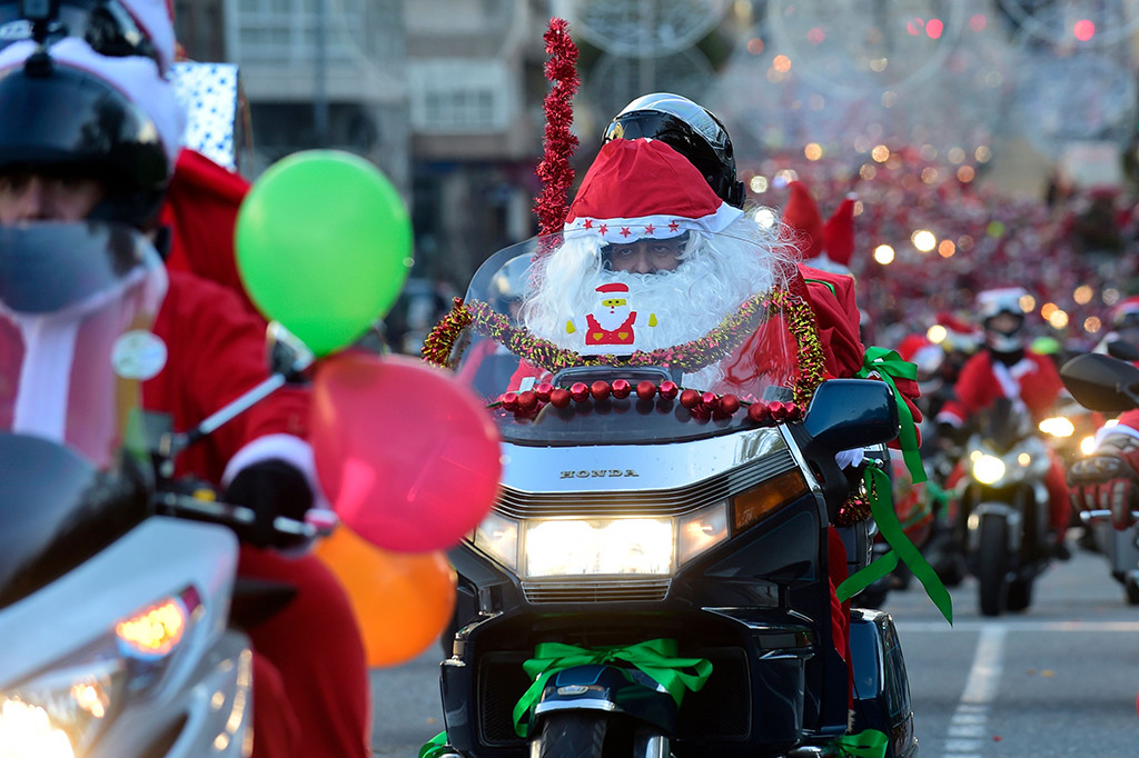 Jika pada umumnya Santa mengendari kereta luncur rusa, di Spanyol, sejumlah Santa mengendarai motor gede dalam acara 'Papanoelada' di Kota Vigo.  AFP PHOTO / MIGUEL RIOPA