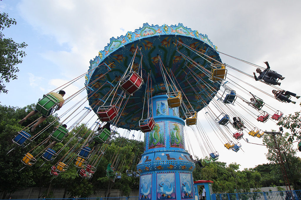 Sejumlah pengunjung bermain 'Wave Swinger' di Atlantis Land, Surabaya, Jawa Timur. Wahana wisata baru tersebut ramai dikunjungi oleh warga yang berasal dari Surabaya maupun dari daerah lain di Jawa Timur untuk memanfaatkan liburan Natal dan Tahun Baru 2018. ANTARA/Didik Suhartono