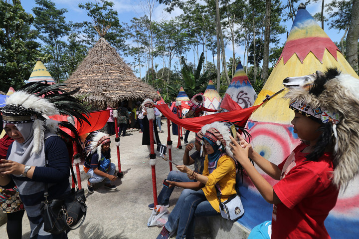 Sejumlah pengunjung berfoto di Kampung Indian yang dibangun di area lereng gunung Kelud, Desa Sempu, Kediri, Jawa Timur. Tempat wisata yang baru dibuka pada bulan Agustus 2017 dan telah populer di media sosial sebagai tempat swafoto tersebut pada libur Natal ramai dikunjungi wisatawan dari berbagai daerah. ANTARA FOTO/Prasetia Fauzani