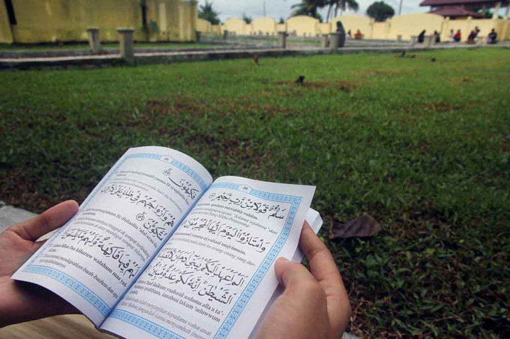 Umat muslim membaca Surat Yasin saat berziarah ke kuburan massal korban gempa dan gelombang tsunami di Desa Suak Indrapuri, Johan Pahlawan, Aceh Barat, Aceh, Selasa, 26 Desember 2017. ANTARA/Syifa Yulinnas