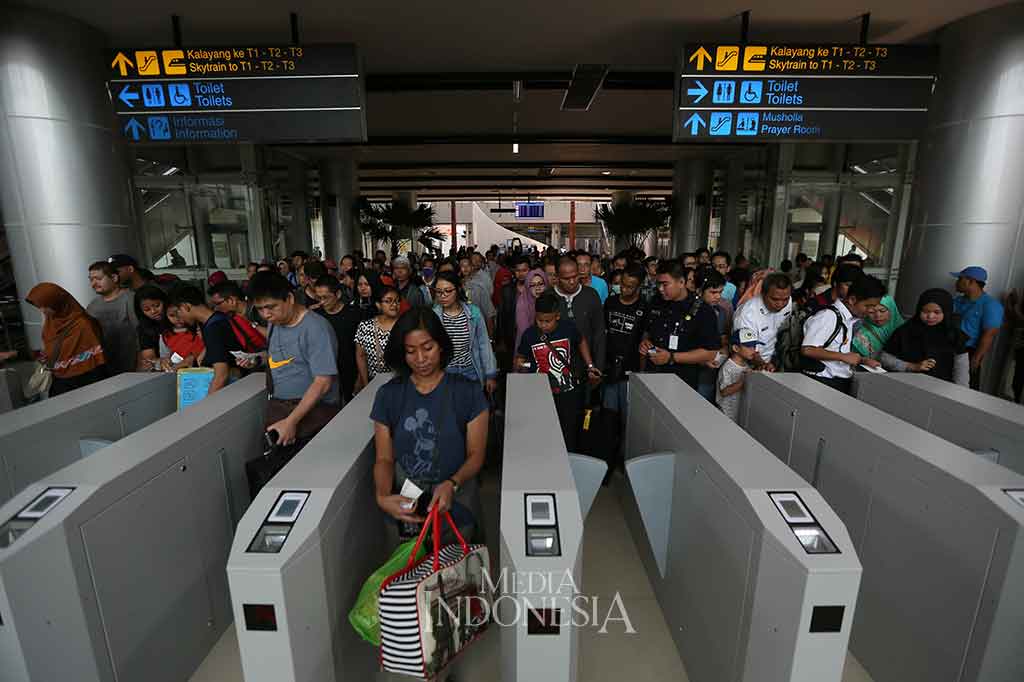 Calon penumpang antre saat akan naik Kereta Bandara Soekarno-Hatta menuju Stasiun Stasiun Sudirman Baru (BNI City) di Stasiun Bandara Internasional Soekarno Hatta, Tangerang, Banten.
