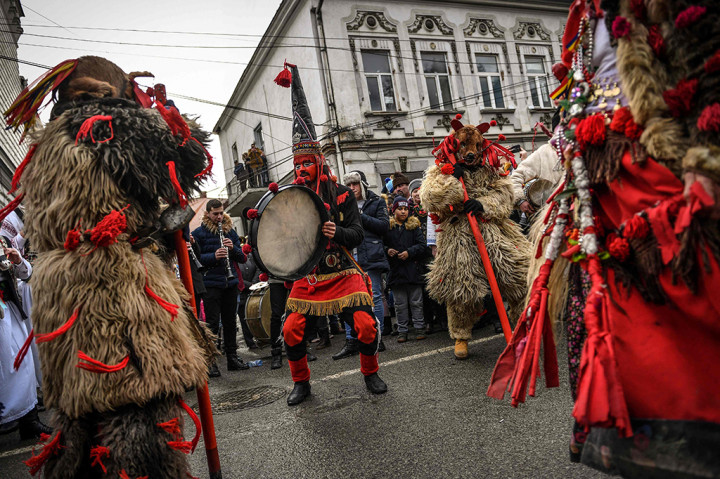 Sejumlah kelompok dari desa di Rumania utara mengenakan kostum dan menyanyikan lagu-lagu dan tarian musim dingin, menyambut tahun baru. AFP PHOTO / Daniel MIHAILESCU
