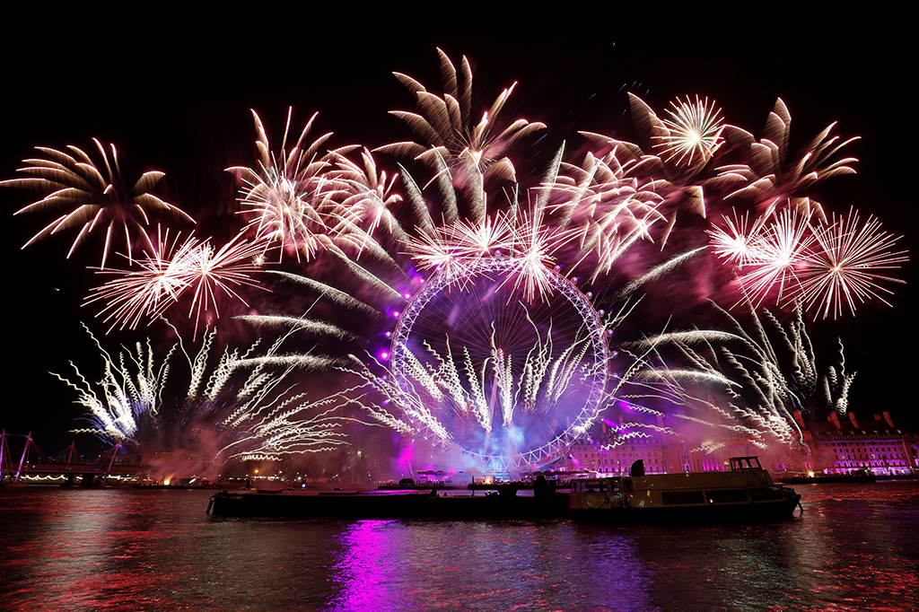 Warna-warni kembang api menghiasi London Eye, saat malam tahun baru. AFP PHOTO / Tolga AKMEN