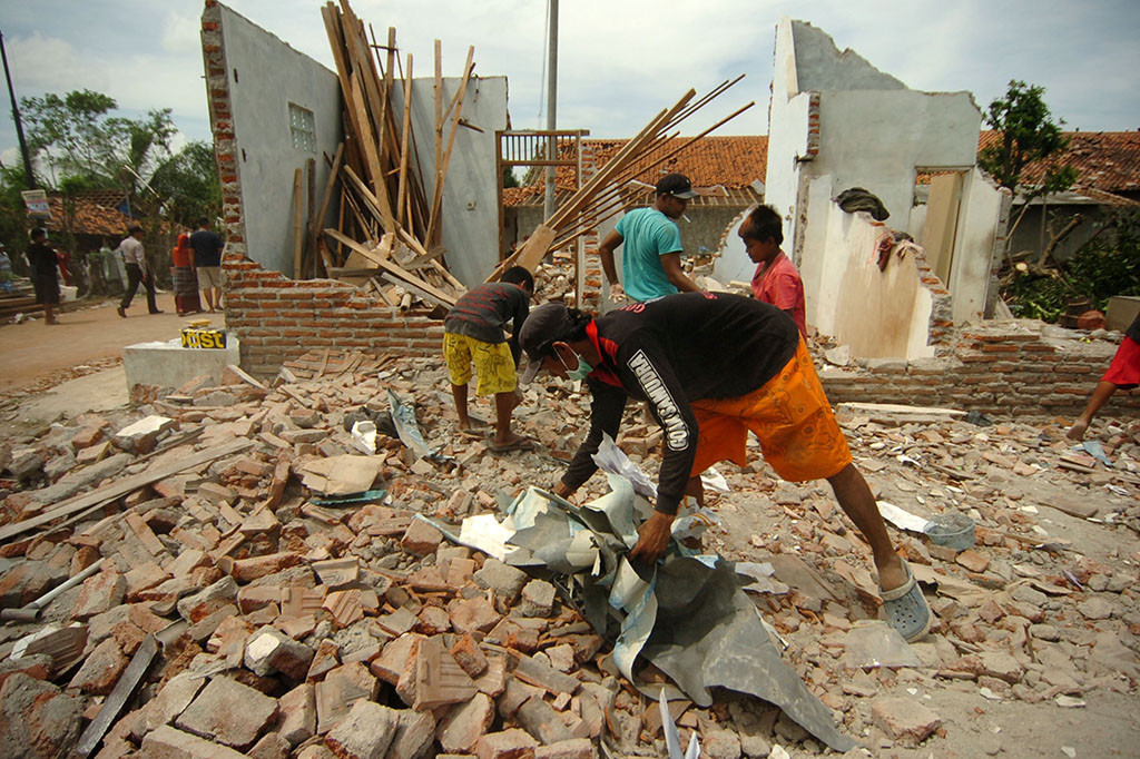 Warga membersihkan puing-puing rumahnya yang hancur karea angin puting beliung di Desa Bojongnangka, Pemalang.
