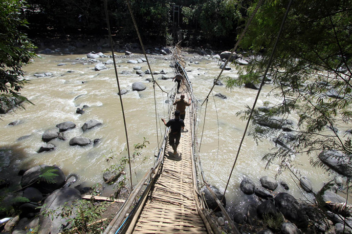 Sejumlah personel Polisi menyelidiki jembatan gantung yang ambruk menghubungkan Desa Sirna Sari dan Desa Buana Jaya, Tanjung Sari, Bogor, Jawa Barat.