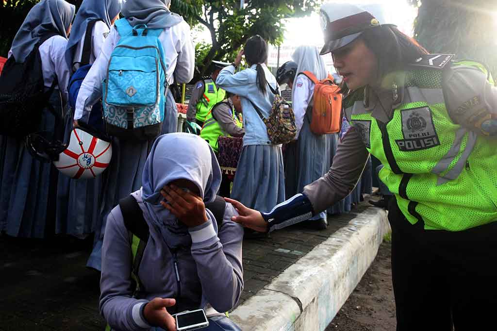 Seorang anggota Polisi Wanita (Polwan) berusaha menenangkan seorang pelanggar yang menangis histeris karena ditilang saat pelaksanaan operasi penindakan terhadap pengendara motor pelajar di bawah umur di Blitar, Jawa Timur, Rabu, 3 Januari 2018.