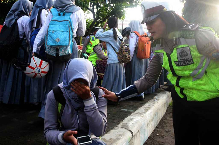 Seorang anggota Polisi Wanita (Polwan) berusaha menenangkan seorang pelanggar yang menangis histeris karena ditilang saat pelaksanaan operasi penindakan terhadap pengendara motor pelajar di bawah umur di Blitar, Jawa Timur, Rabu, 3 Januari 2018.