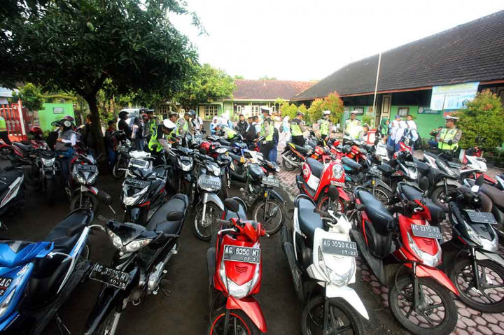 Seorang anggota Polisi Wanita (Polwan) berusaha menenangkan seorang pelanggar yang menangis histeris karena ditilang saat pelaksanaan operasi penindakan terhadap pengendara motor pelajar di bawah umur di Blitar, Jawa Timur, Rabu, 3 Januari 2018.