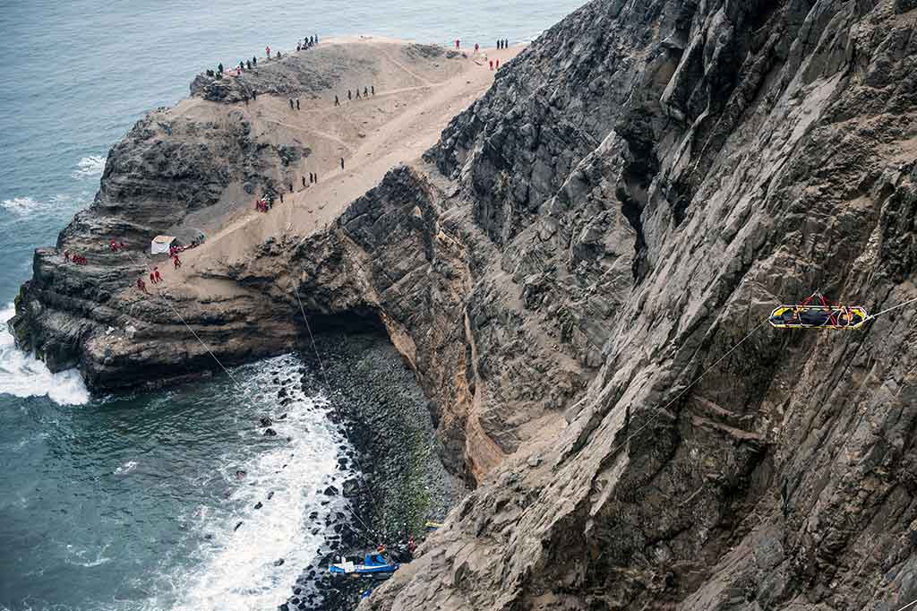 Petugas dengan bantuan tali bersusah payah mengevakuasi korban kecelakaan tersebut dari dasar tebing.