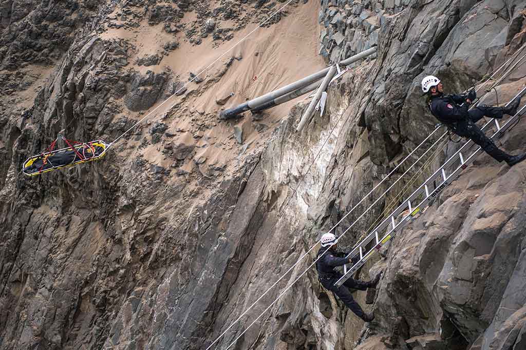 Perjuangan para petugas saat mengevakuasi korban kecelakaan. Mereka harus menuruni tebing dengan bantuan tali.