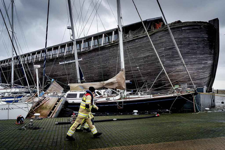 Seorang pria berjalan melewati kapal Museum De VerhalenArk yang terdampar setelah disapu angin kencang di Pelabuhan di Urk, Belanda, saat badai Eleanor menyapu negara tersebut. AFP/ANP/Robin van Lonkhuijsen