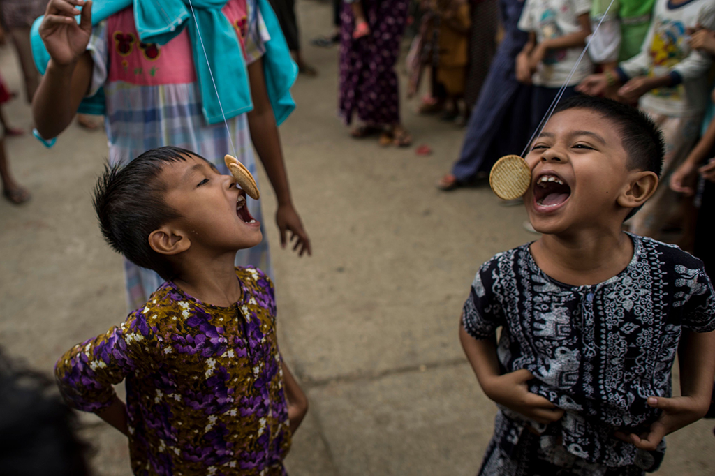 Anak-anak mengikuti lomba makan kue untuk memeriahkan HUT ke-70 Myanmar.