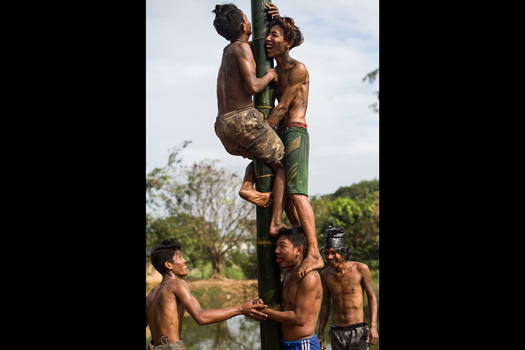 Sejumlah warga mengikuti lomba panjat pinang untuk memeriahkan HUT ke-70 Myanmar.