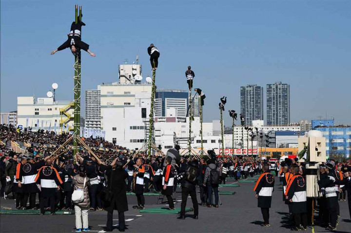 Sejumlah anggota Edo Firemanship Preservation Association melakukan atraksi di atas tangga bambu saat merayakan Tahun Baru di Tokyo, 6 Januari 2018.