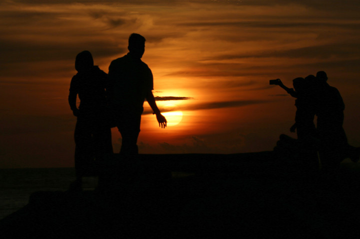 Wisatawan domestik dan mancanegara menikmati suasana senja dengan panorama matahari terbenam (sunset) di pantai wisata Lampuuk, Aceh Besar, Aceh. ANTARA/Irwansyah Putra