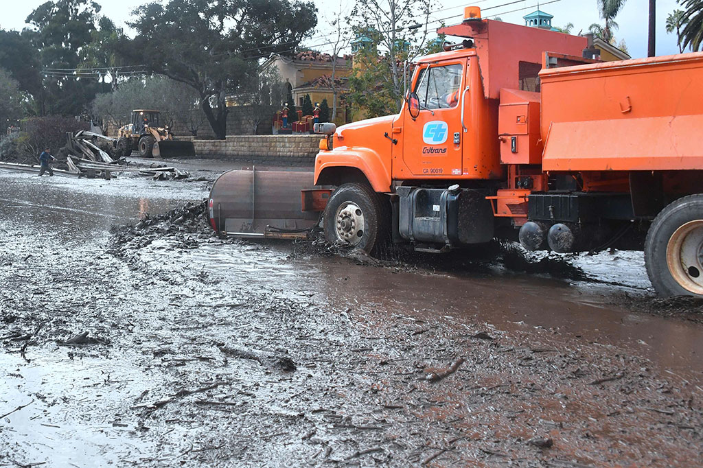 Petugas membersihkan lumpur dan puing-puing di jalanan lepas pantai AS 101 antara San Ysidro dengan Montecito, California, Selasa, 9 Januari 2018 waktu setempat.